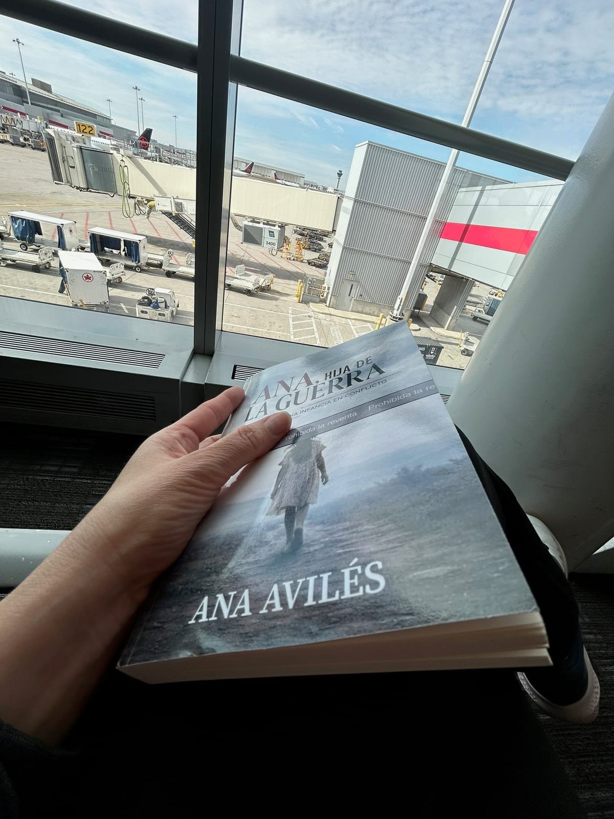 A copy of Ana, Hija de la Guerra held up at an airport gate