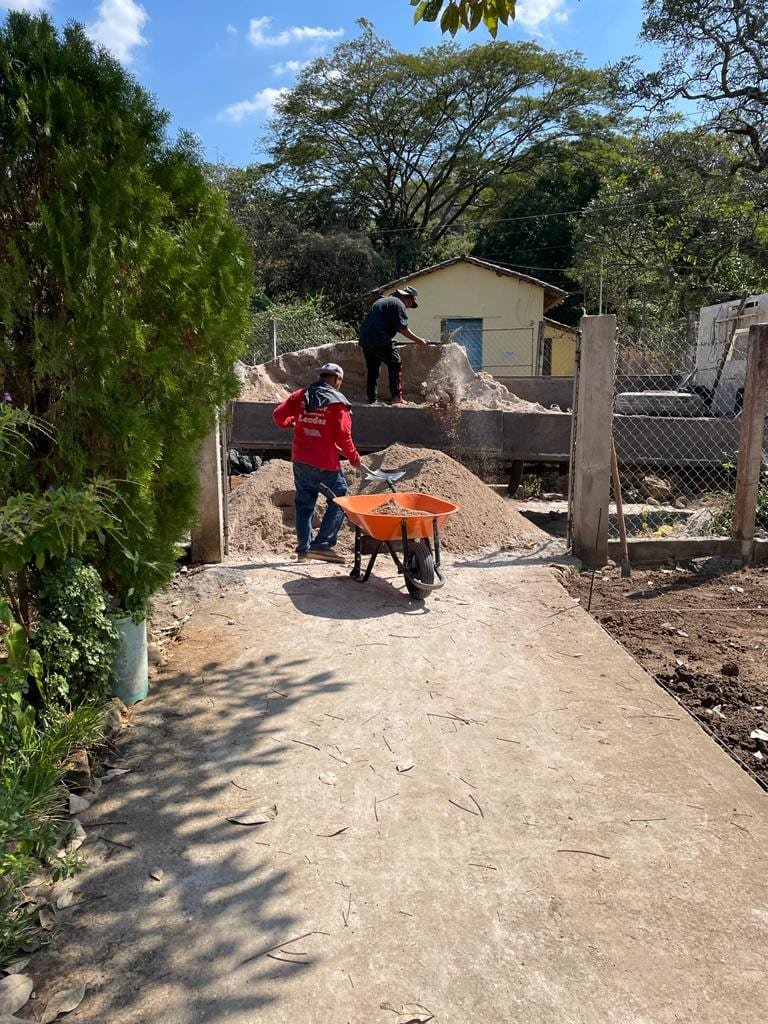 Workers moving sand and gravel by wheelbarrow during construction