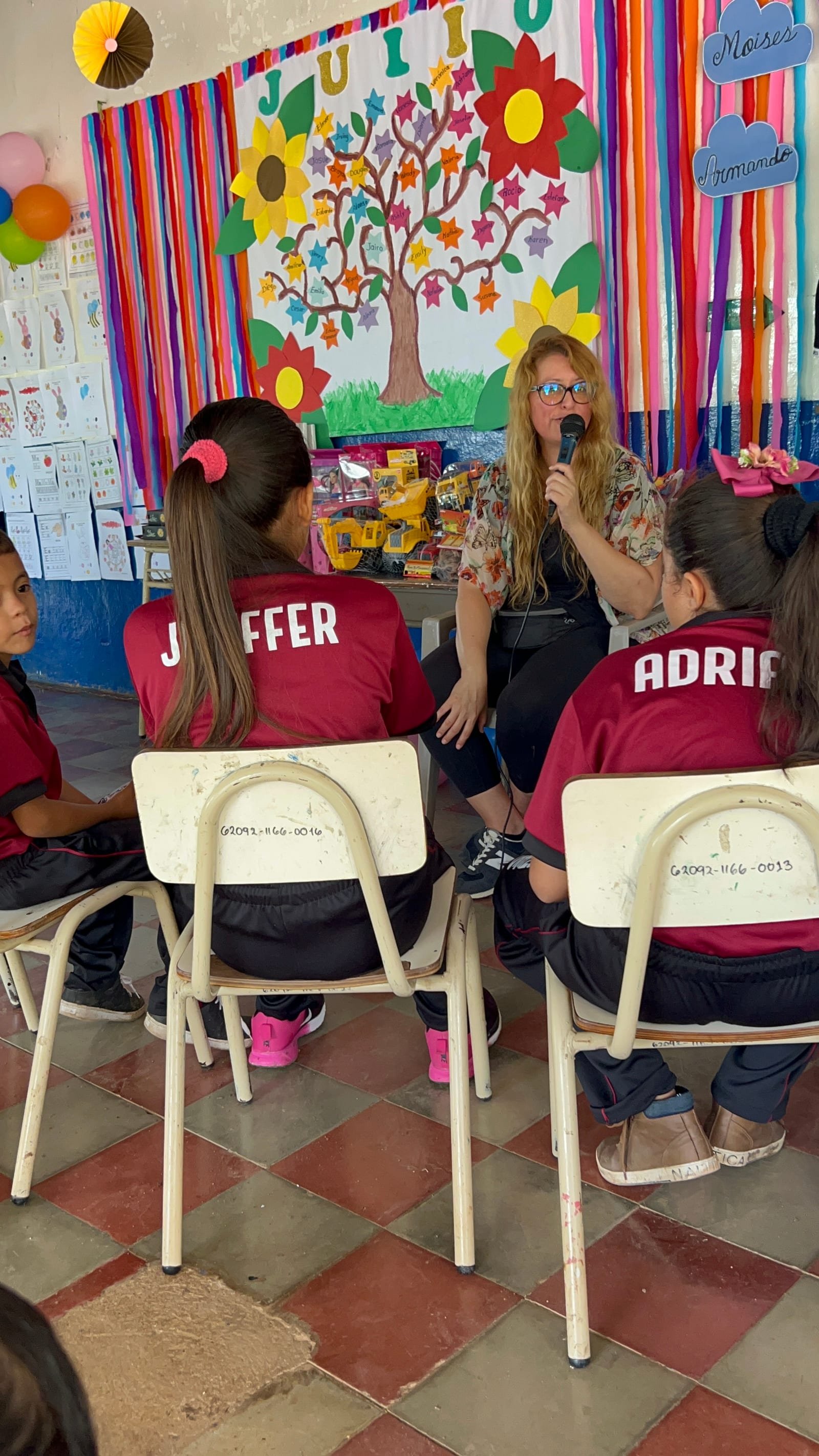 A classroom decorated for a reading event, with a teacher holding a microphone