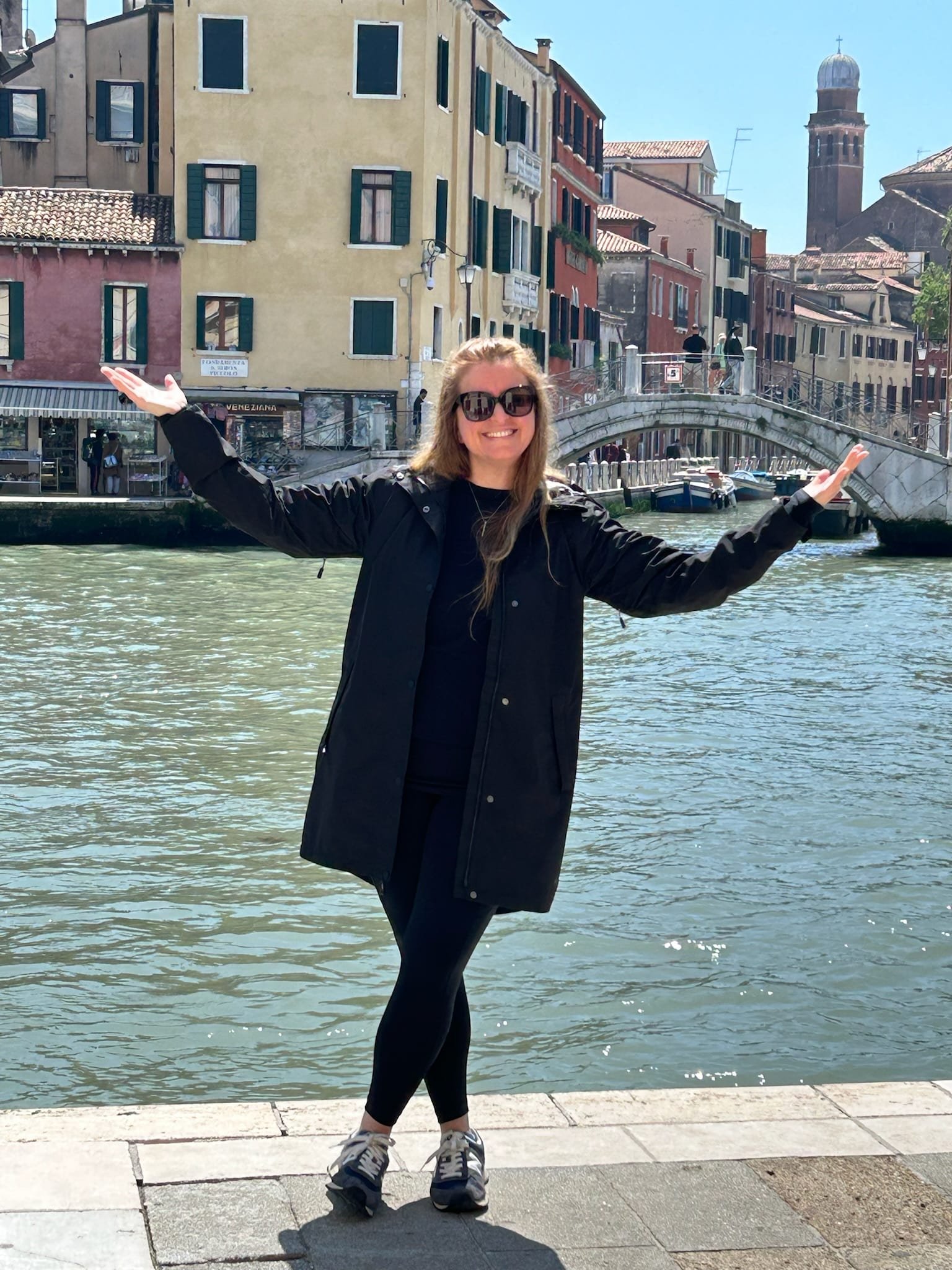 Ana Avilés with arms outstretched beside a canal in Venice